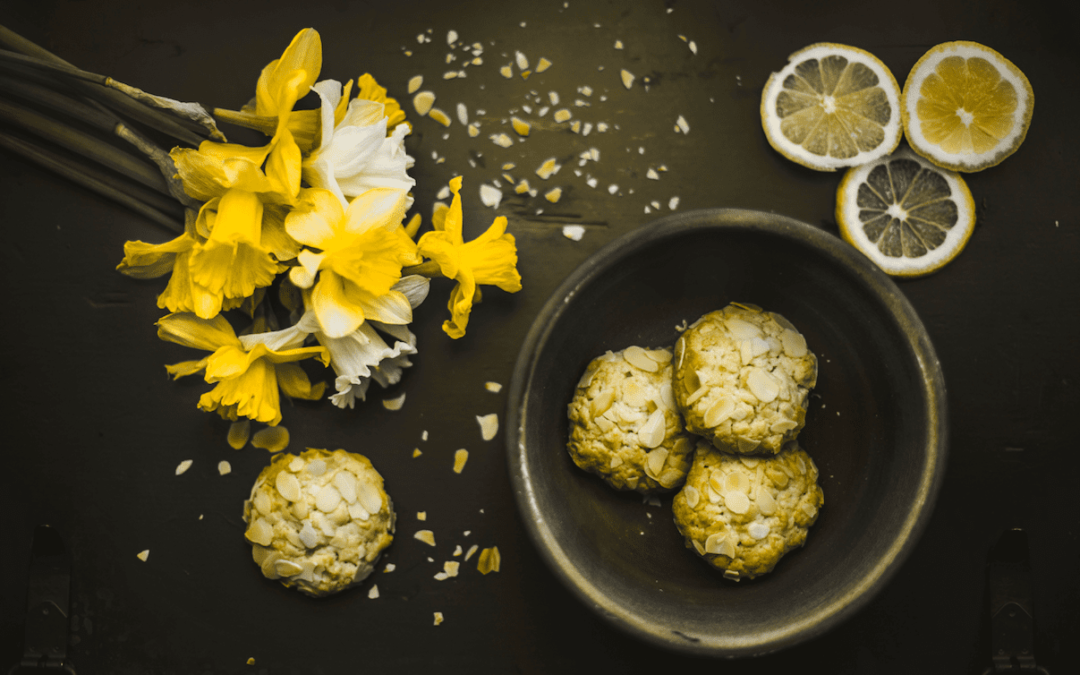 Lemon cookies with daffodils on a black table at a small business marketing workshop.