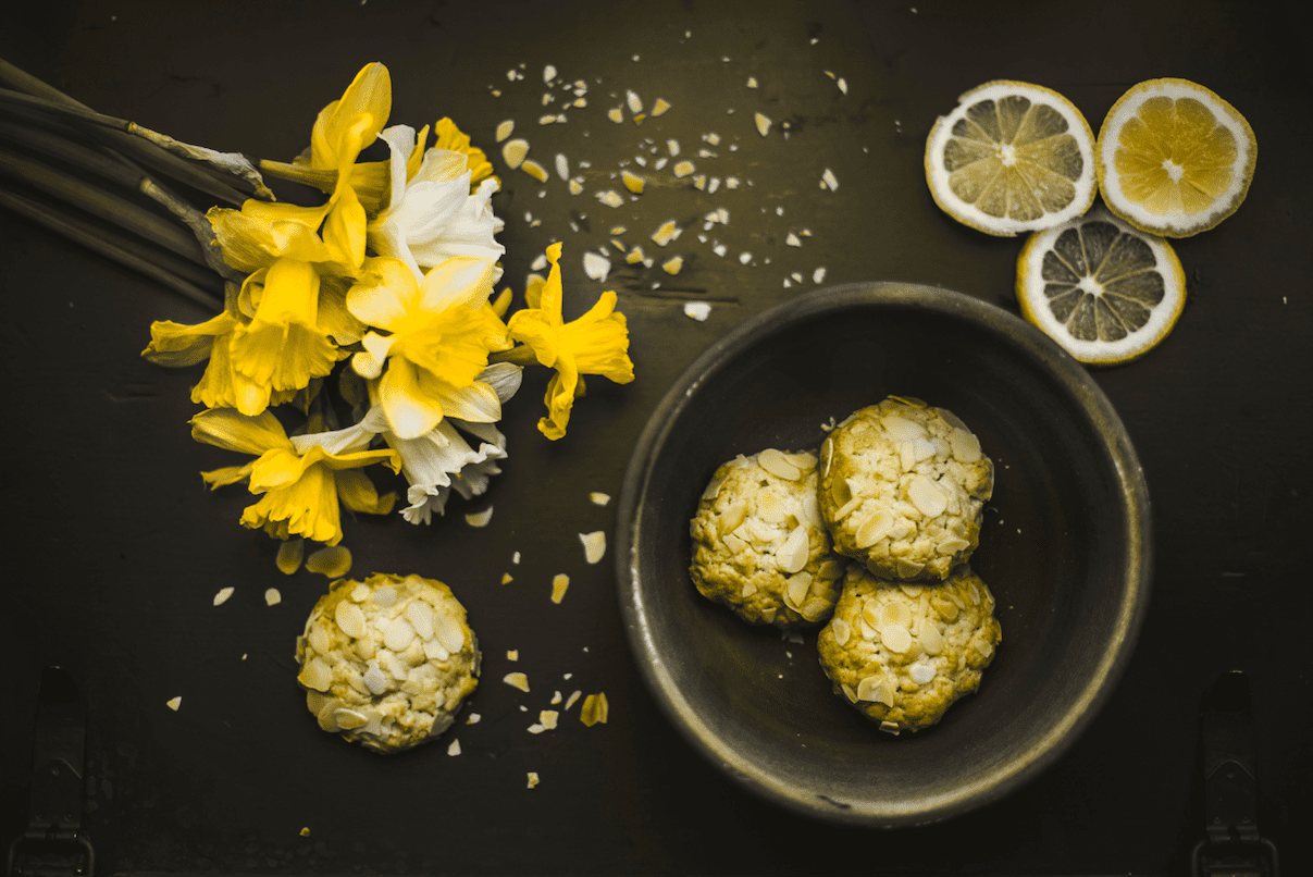 Lemon cookies with daffodils on a black table at a small business marketing workshop.