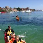 A small group of people in a kayak participating in a team-building workshop.