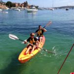 Two people paddling a kayak in the water during a small business marketing workshop.