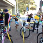 A group of people participating in a marketing workshop, standing around a group of bicycles.