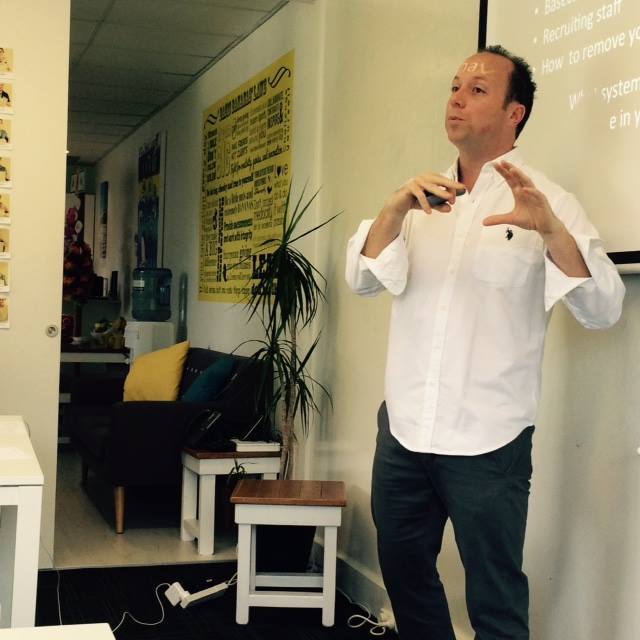 A man standing in front of a projector giving a marketing presentation.