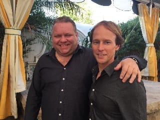 Two men posing for a picture during a marketing workshop.