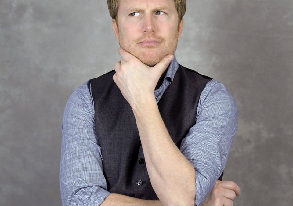 A man posing with his hand on his chin, contemplating his marketing plan for a small business marketing workshop.