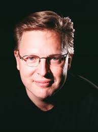 A man wearing glasses and a black shirt attending a marketing workshop.