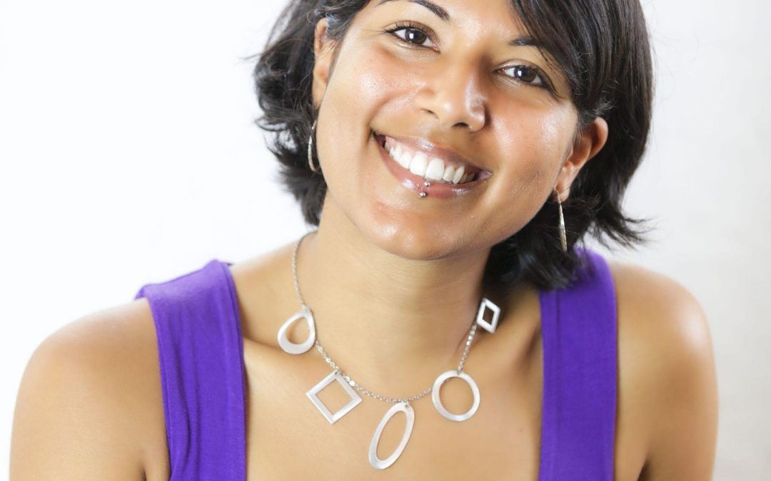 A smiling woman in a purple top learning marketing strategies at a small business marketing workshop.