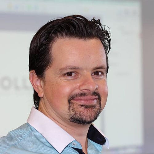 A man in a blue shirt is smiling while participating in a marketing workshop.