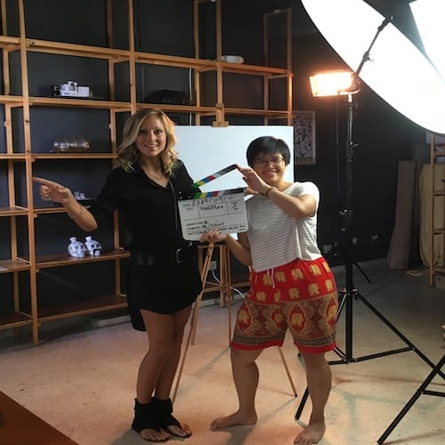 Two women participating in a marketing workshop, posing in front of a camera in a studio.