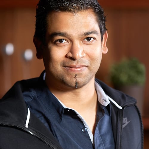 A man in a black jacket is smiling for the camera during a marketing workshop.