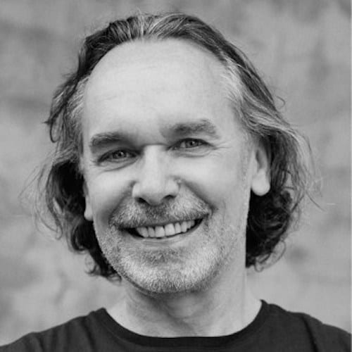 A black and white photo of a man smiling during a marketing workshop.