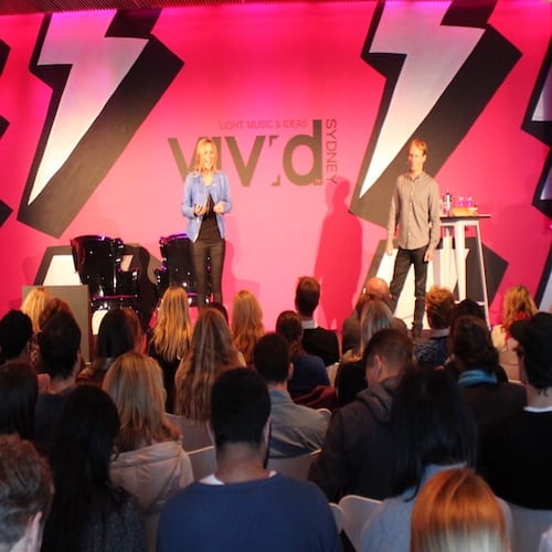 A group of people attending a small business marketing workshop standing in front of a stage.