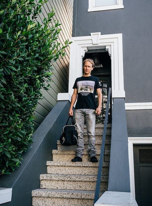 A man standing on the steps of a house attending a marketing workshop.