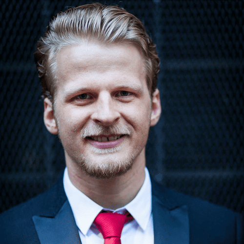 A man in a suit and red tie providing mentoring on small business marketing.