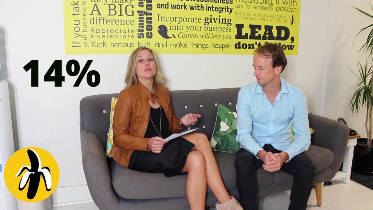 A man and woman are sitting on a couch talking about small business marketing.