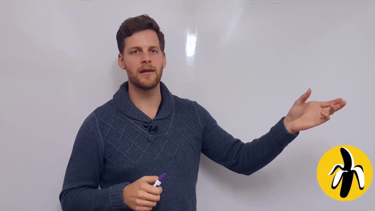 A man conducting a marketing workshop in front of a white board, providing mentoring on small business marketing strategies.