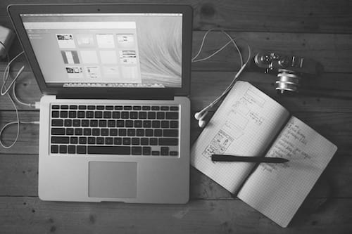 A black and white photo of a laptop on a wooden table, showcasing a small business marketing workshop.