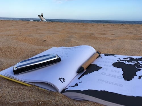A small business marketing notebook with a map and a pen on the beach, designed for a marketing workshop or mentoring session.