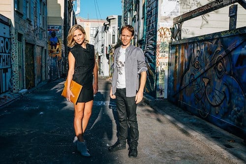 Two people attending a marketing workshop in an alley with graffiti on the walls.