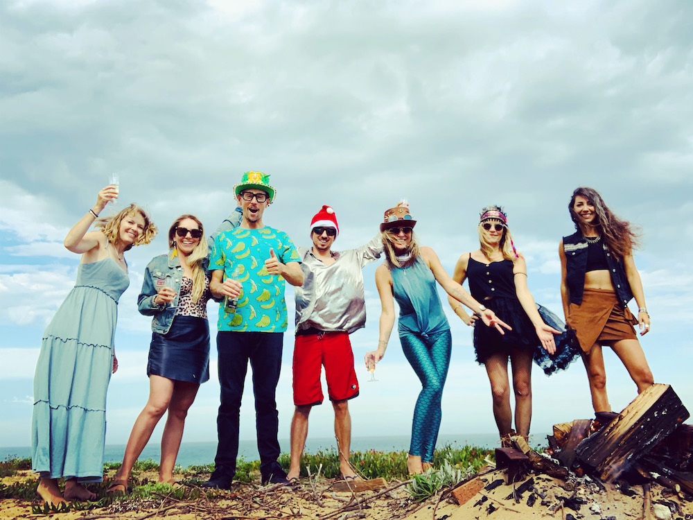 A group of people posing for a photo on the beach during a marketing workshop.