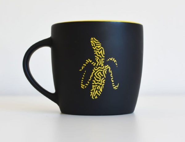 A black and yellow A Cuppa Genius with a banana on it, perfect for small business marketing.