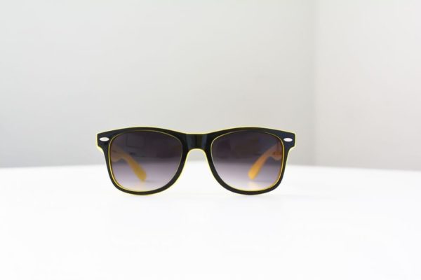 A pair of I See You Sunglasses displayed on a white table during a marketing workshop.
